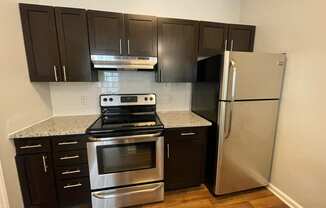 Kitchen with stainless steel appliances and black cabinets at The Chase, Burlington, NC