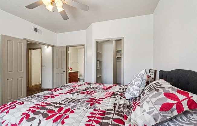A bedroom with a large bed and a ceiling fan.