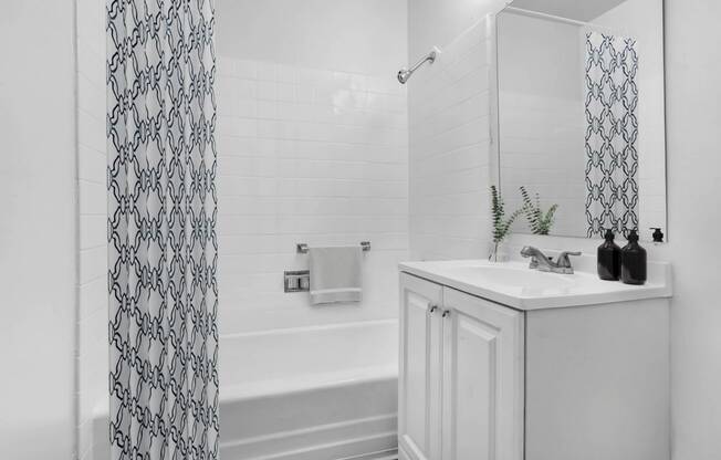 a bathroom with a sink and a tub and a shower curtain