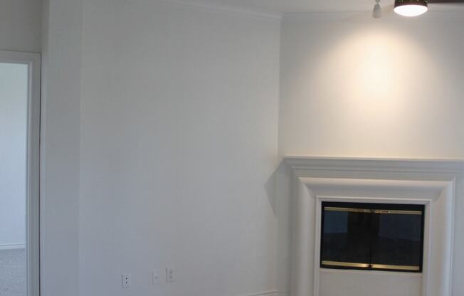 an empty living room with white walls and a fireplace