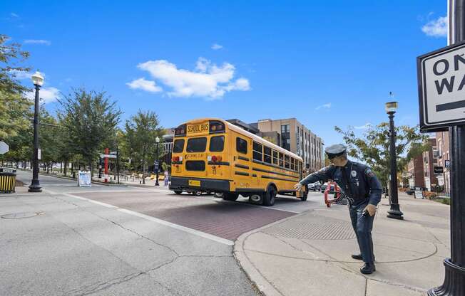 a school bus driving down a street with a man on the sidewalk