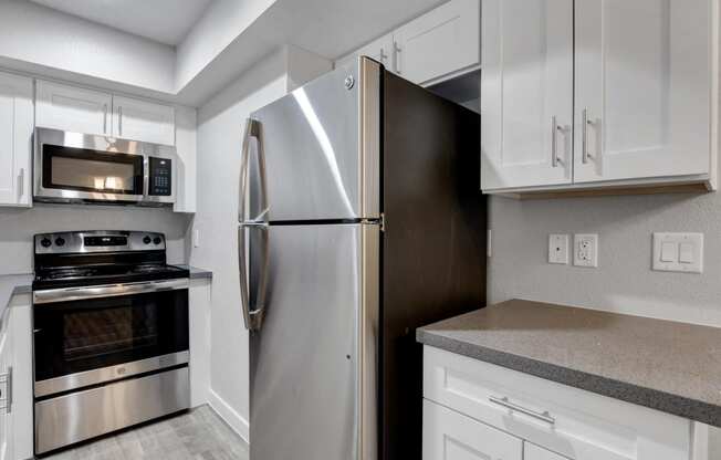 a kitchen with stainless steel appliances and white cabinets