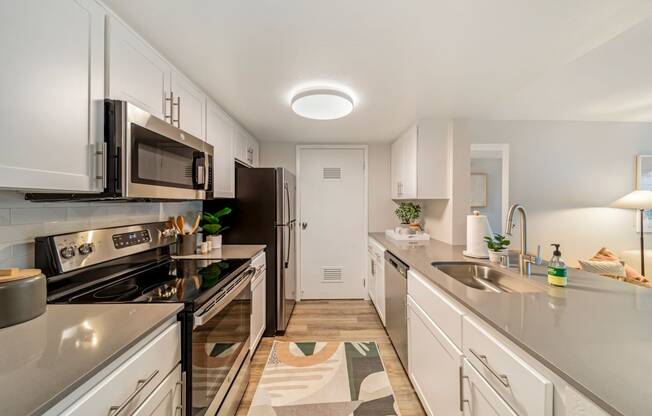 a kitchen with white cabinets and stainless steel appliances  at Citrine Hills, California, 91761