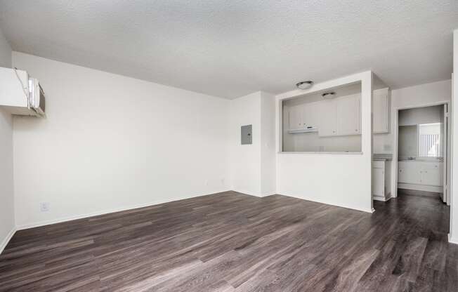 an empty living room with white walls and wood flooring