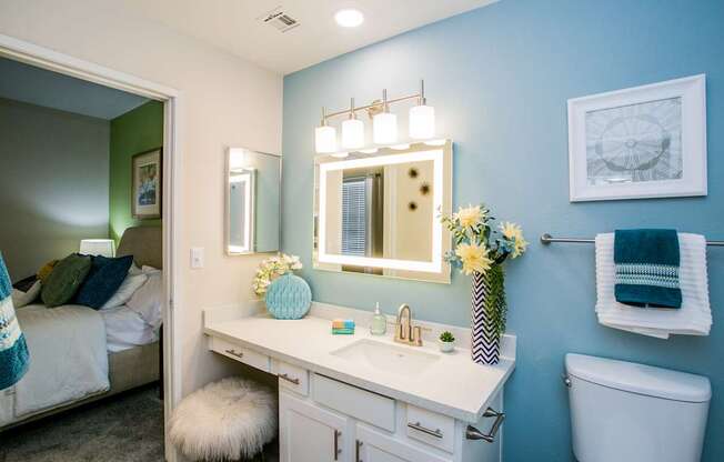 A bathroom with a white vanity and a white toilet.