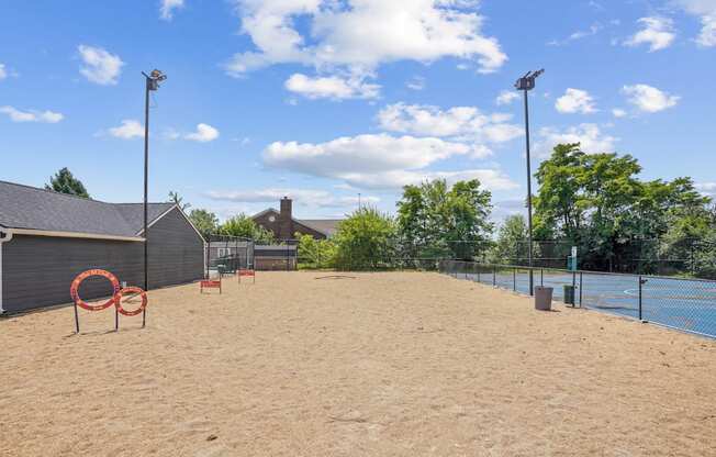 A sandy beach area with a fence and a blue sky.