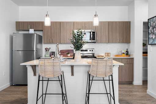 A modern kitchen with a white countertop and wooden cabinets.