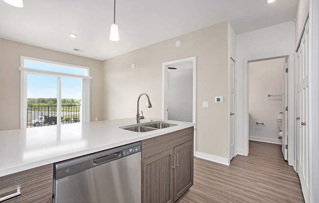A modern kitchen with a dishwasher, sink, and cabinets at Meadowbrooke Apartment Homes in Kentwood, MI 49512