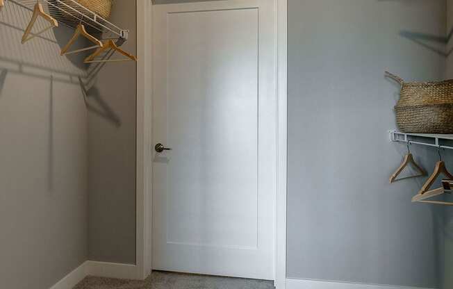 a walk in closet with gray walls and a white door