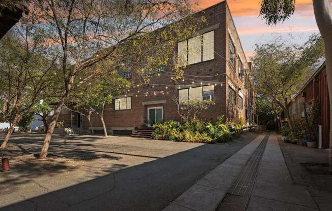 A long building with a lot of windows and plants in front.