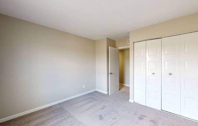a bedroom with a closet and a door to a hallway
