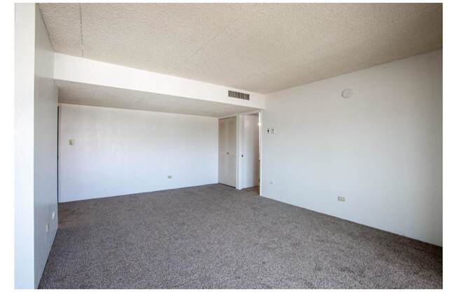 A room with carpeted floor and white walls.