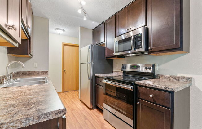 a kitchen with stainless steel appliances and wooden cabinets