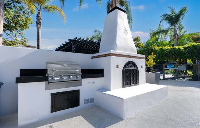 A white outdoor kitchen with a grill and oven.