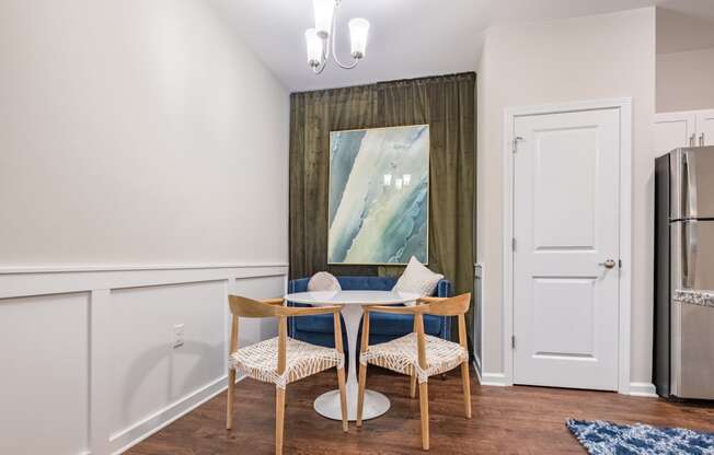 a dining room with a table and chairs and a refrigerator