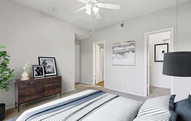 A carpeted bedroom with a closet and connected bathroom at Jefferson Creek Apartments in Irving, TX