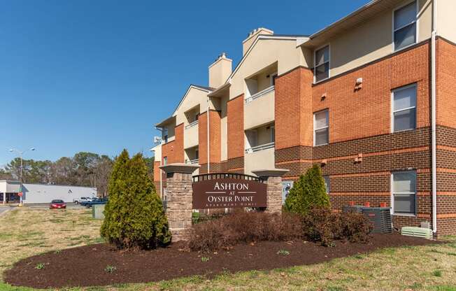 an apartment building with a brick exterior and a sign