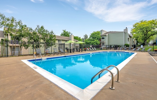 A large outdoor swimming pool with a metal ladder on the side.