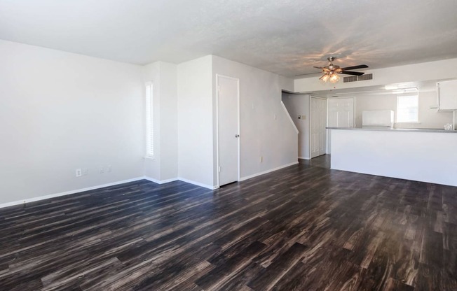 a living room with a hard wood floor and a ceiling fan
