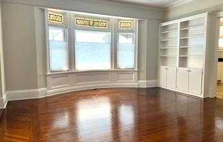 a living room with a wooden floor and a large window