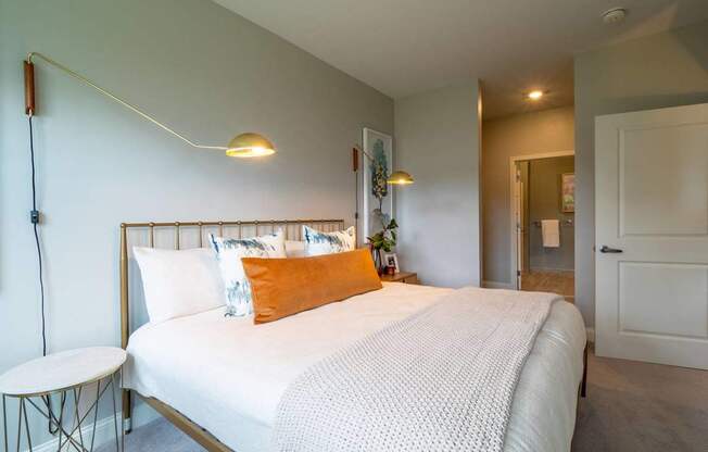 A serene bedroom with a queen-size bed, decorative pillows, a nightstand, and soft lighting for a cozy ambiance.