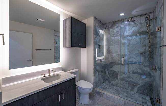 A bathroom with a sink, toilet, and shower.