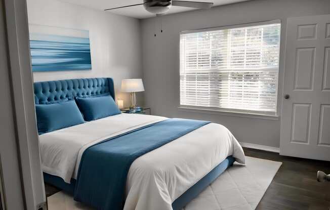 a bedroom with a blue and white bed and a ceiling fan