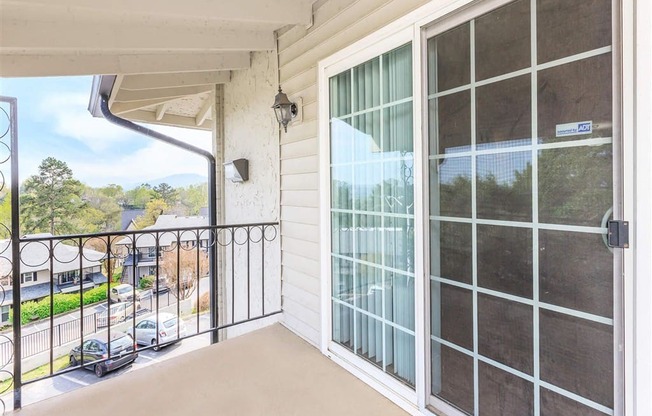A balcony with a glass door and a metal railing.
