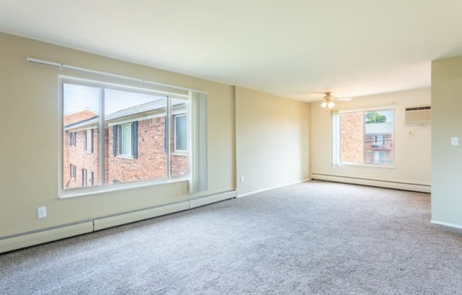 the living room of an empty house with large windows