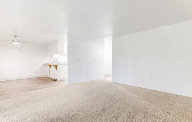 an empty living room with white walls and carpet