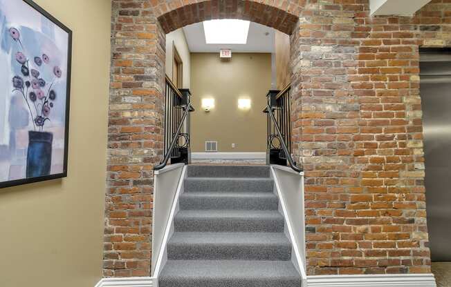 a staircase with brick walls and an arched doorway