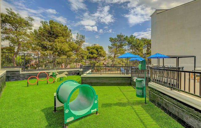 A playground with a green slide and red and green play equipment.