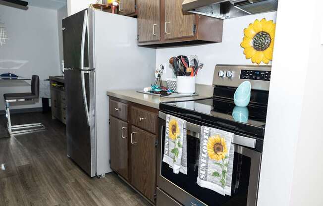 A kitchen with a refrigerator, oven, and a stove top.