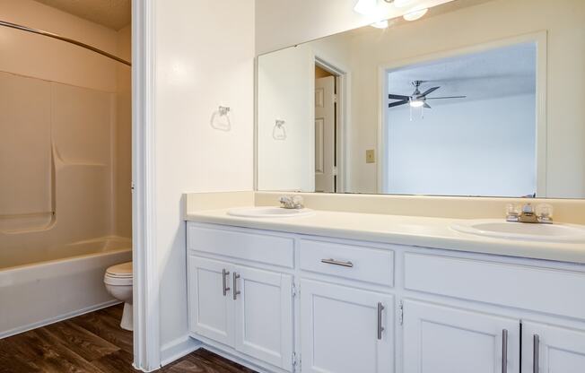 bathroom with white cabinetry and hardwood-style flooring