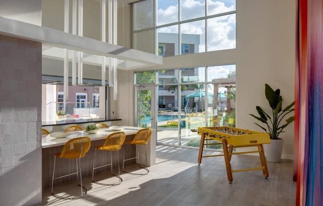 A brightly lit room with a yellow table and chairs.