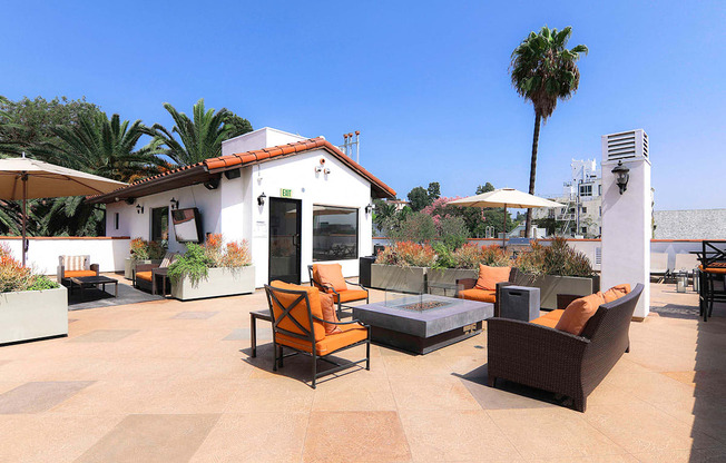 Open air rooftop patio with gas firepit, BBQs, several seating locations, and cable television.