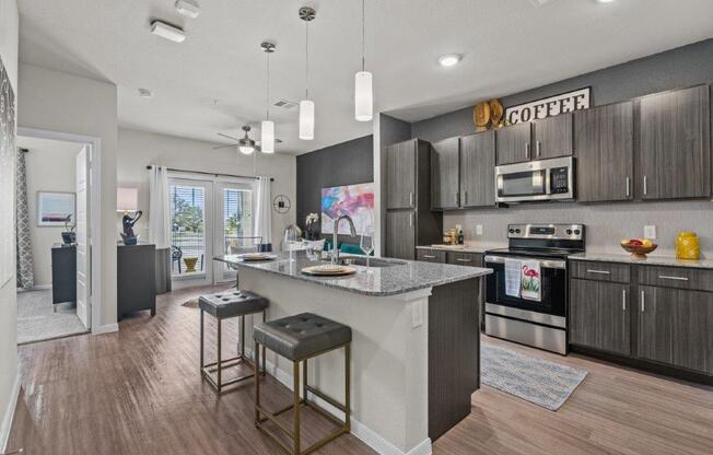 a kitchen with a large island with two stools