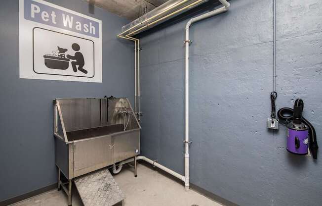 A Pet Wash sign is on the wall above a large metal tub.