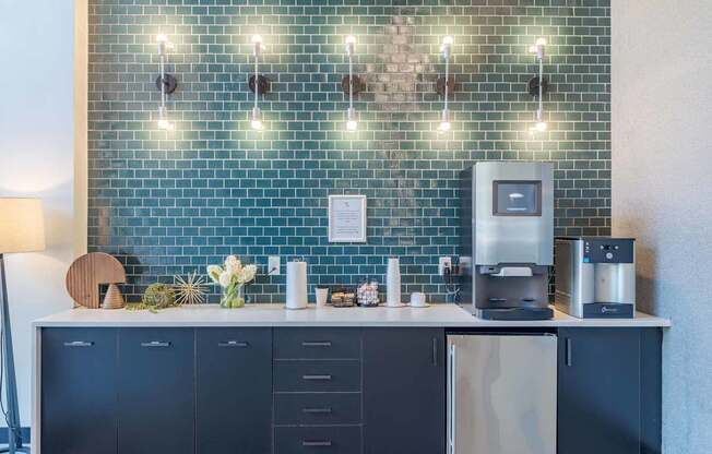 A kitchen with a blue tiled wall and a coffee machine.