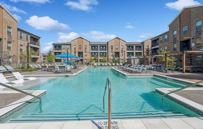 Community Swimming Pool with Pool Furniture at Alta 3Eighty Apartments located in Aubrey, TX.