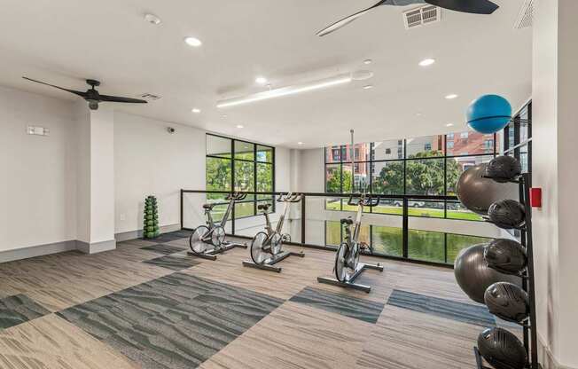 A room with a ceiling fan, exercise equipment, and a view of the outdoors.