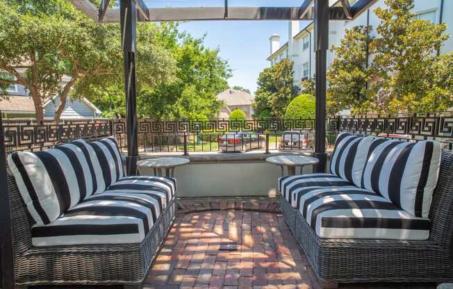 a patio with blue and white striped chairs and tables