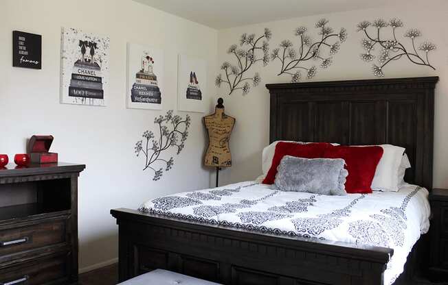 a bedroom with a bed and a dresser and pictures on the wall