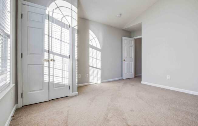 an empty living room with white doors and white walls