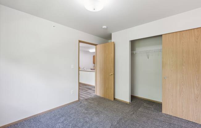 a bedroom with a closet and a door to a bathroom