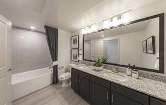 a bathroom with a large mirror and a toilet and a shower