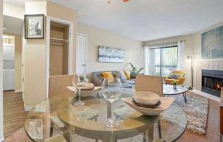 A modern dining room with a glass table and chairs.