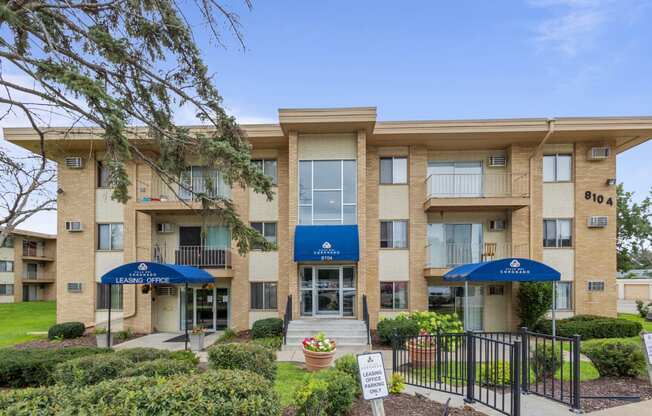 an apartment building with umbrellas and a sign in front