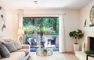A living room with a white couch, a coffee table, and a fireplace.