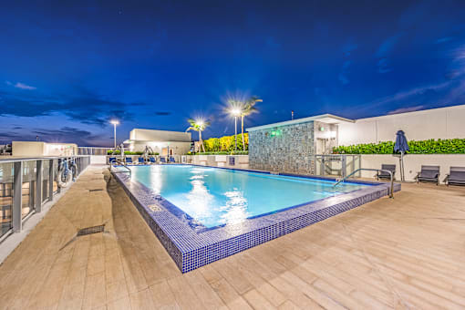 a swimming pool on the rooftop of a hotel at night